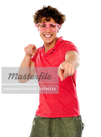 Handsome guy pointing at camera wearing heart shape pink glasses