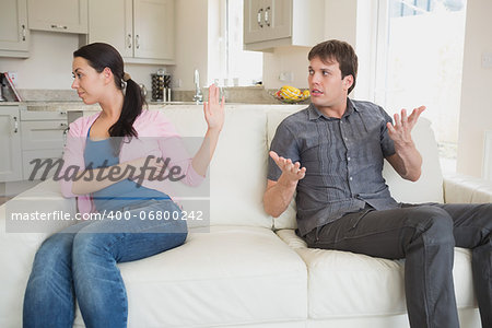 Young people disputing on the couch in the living room