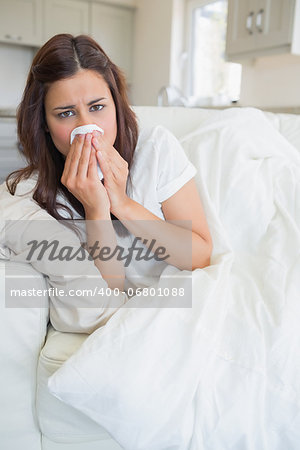 Woman feeling sick and lying on the sofa