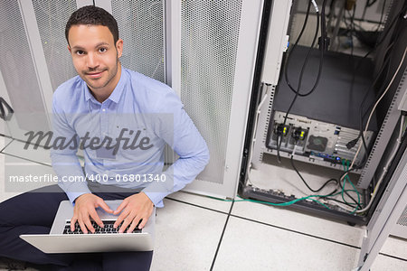 Man smiling while doing server maintenance on the floor