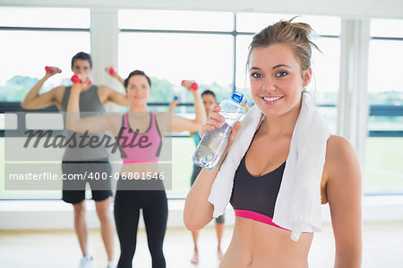 Woman taking break from aerobics class with bottled water