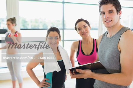 Trainer and women smiling in fitness studio