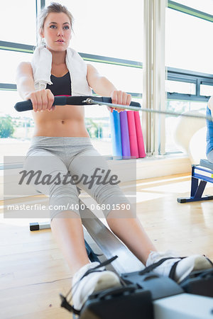 Woman on the rowing machine in fitness studio