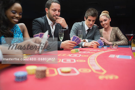 Happy people playing poker in casino
