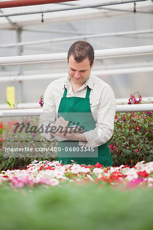 Man taking notes in greenhouse in garden center