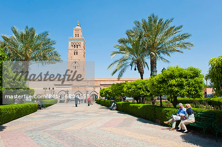 Tourists sitting in the gardens next to the Koutoubia Mosque, Marrakech (Marrakesh), Morocco, North Africa, Africa