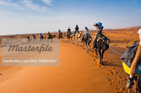 Tourists on a camel ride in Erg Chebbi Desert, Sahara Desert near Merzouga, Morocco, North Africa, Africa Tourists on a camel ride in Erg Chebbi Desert, Sahara Desert near Merzouga, Morocco, North Africa, Africa