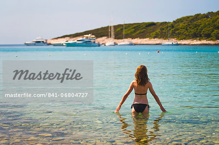 Tourist swimming on a beach in the Pakleni Islands (Paklinski Islands), near Hvar Island, Dalmatian Coast, Adriatic Sea, Croatia, Europe