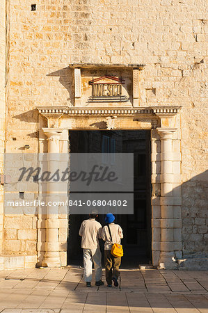 Tourist entering Old Town of Trogir through the South Town Gate, Trogir, UNESCO World Heritage Site, Dalmatian Coast, Croatia, Europe