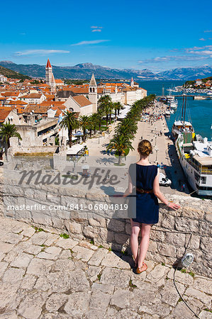 Tourist admiring the view from Kamerlengo Fortress over Trogir waterfront, Trogir, UNESCO World Heritage Site, Dalmatian Coast, Adriatic, Croatia, Europe Tourist admiring the view from Kamerlengo Fortress over Trogir waterfront, Trogir, UNESCO World Heritage Site, Dalmatian Coast, Adriatic, Croatia, Europe
