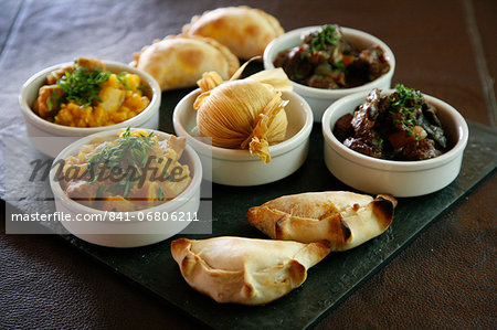 A tray with traditional food from the northwest, including empanadas, locro and humitas, at the restaurant of La Comrca Hotel in Purmamarca, Jujuy Province, Argentina, South America