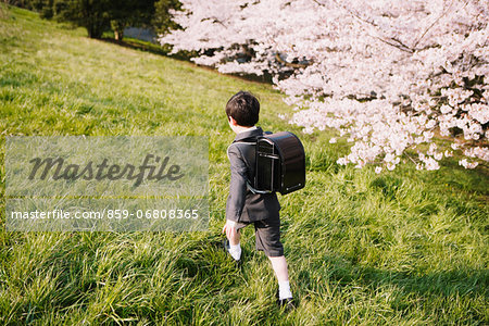 Young boy in a school uniform walking on grass
