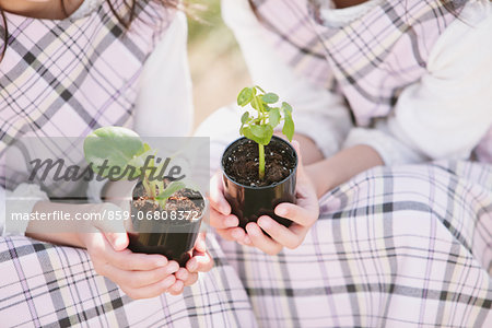 Young girls holding plants