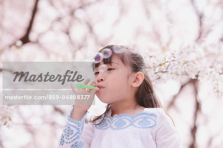 Young girl playing with soap bubbles
