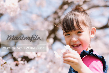 Young girl with cherry blossoms smiling at camera