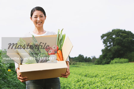 Woman with vegetables smiling at camera