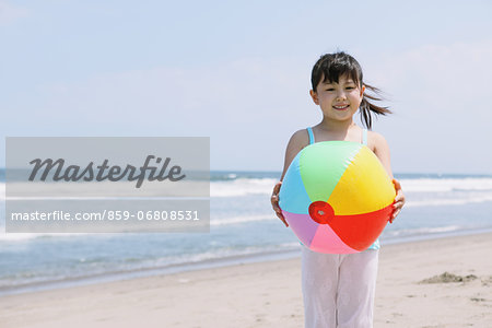 Young girl with ball on the beach