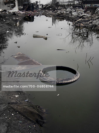 Old tyre in puddle in burnt out wasteland, Saint Denis, France