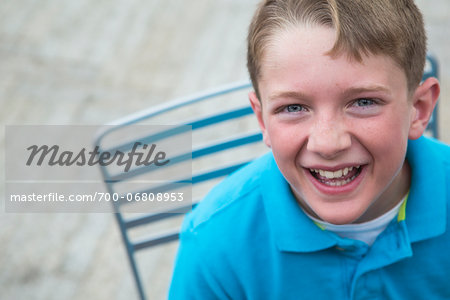 Boy with freckles looking up and laughing.