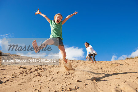 Two girls jumping on beach