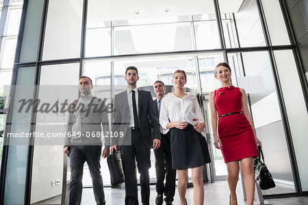 Group of business people entering glass office building