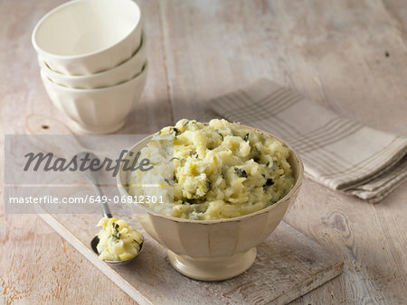 Colcannon potato mash in cream faceted bowl with metal spoon