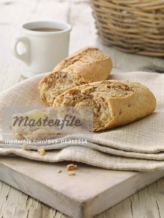 Multi grain baguette with butter on cream linen napkin