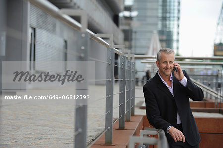 Mature man making cellphone call in financial district