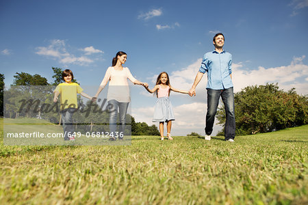 Family with two children holding hands, walking