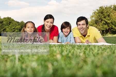 Portrait of family with two children lying on grass