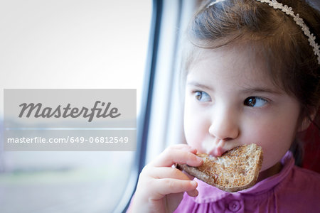 Little girl on train, eating