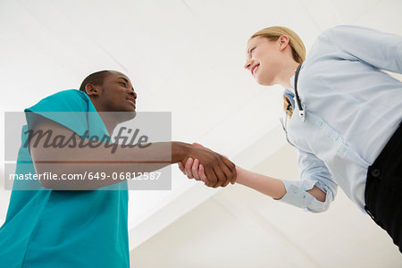 Two doctors shaking hands, low angle