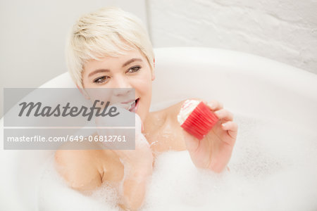 Woman eating cupcake in bubble bath
