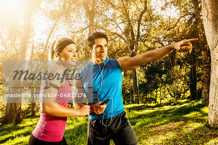 Two people exercising in forest deciding on direction