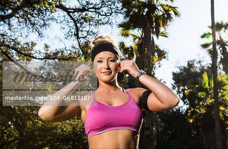 Young woman exercising in forest wearing earphones