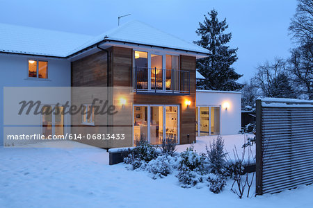 Illuminated family home in snow Illuminated family home in snow
