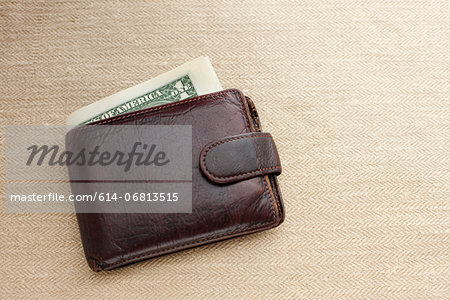 Brown leather wallet with dollar bill