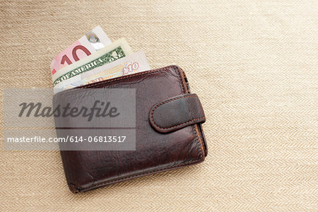 Brown leather wallet with various currencies Brown leather wallet with various currencies