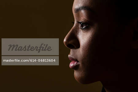 Side view of young woman on black background