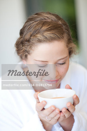Young woman drinking tea with eyes closed