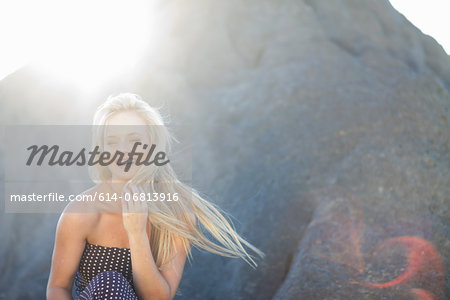 Young woman with long blonde hair on rocks