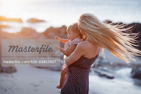 Mother holding daughter on beach