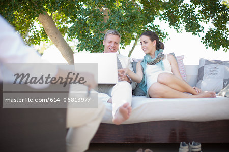 Casual business people on patio using laptop
