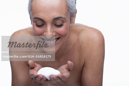Mature woman cleansing face