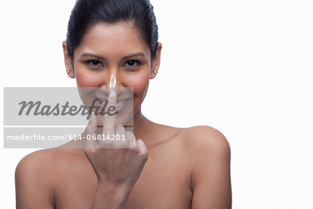 Young woman applying face cream Young woman applying face cream