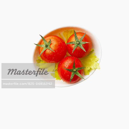 Three tomatoes on celery leaves Three tomatoes on celery leaves