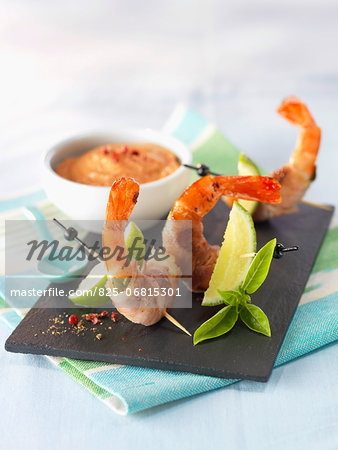 Shrimps wrapped in bacon and basil with cocktail sauce