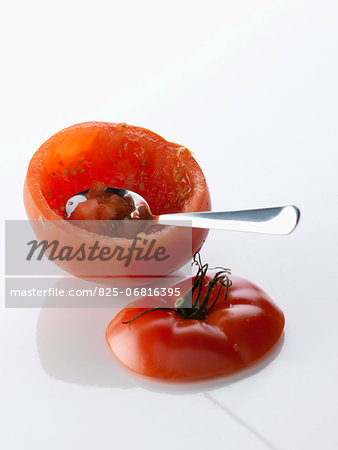 Taking the flesh out of a tomato with a spoon