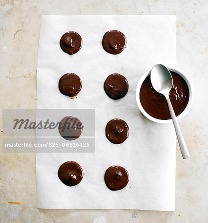 Placing small drops of the melted chocolate on wax paper