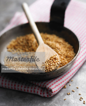 Browning sesame seeds in a frying pan